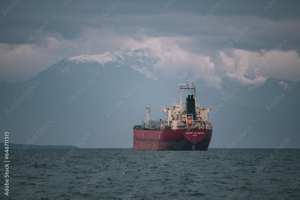  Cargo ship Olympus in the sea with the snowy mountain Olympus in the background winter