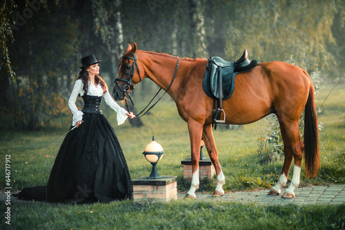 Portrait of magnificent Fashion gothic girl walking a horse .Fantasy art work and fairytale.Amazing brunette model in black-white dress and hat posing.