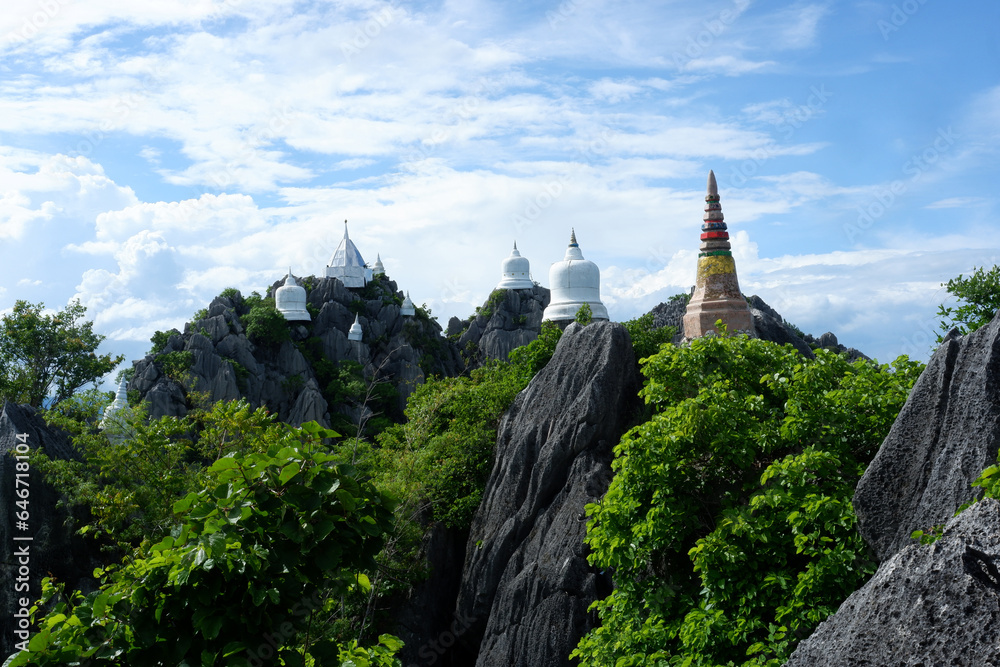 Thai ancient temple. White and gold decoration,Take a high angle.See ancient temple back among with the mountain. Thai ancient temple. White and gold decoration,Take a high angle.See ancient temple back among with the mountain.