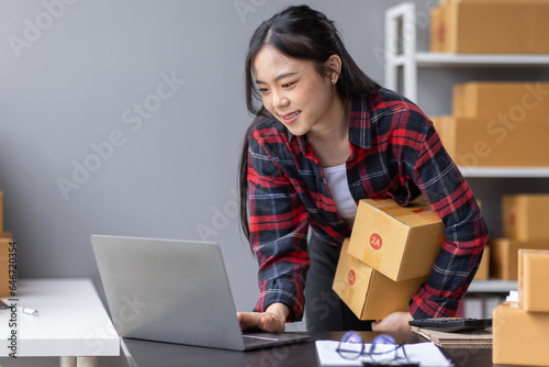 Startup small business entrepreneur SME, asian woman receive order on phone. Success young Asian small business owner home office, online sell marketing delivery, SME e-commerce telemarketing concept  © David