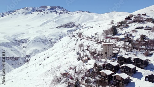 Fly over Farellones with view to the exclusive ski resort of La Parva completely snowed in Chile, sunny day. photo