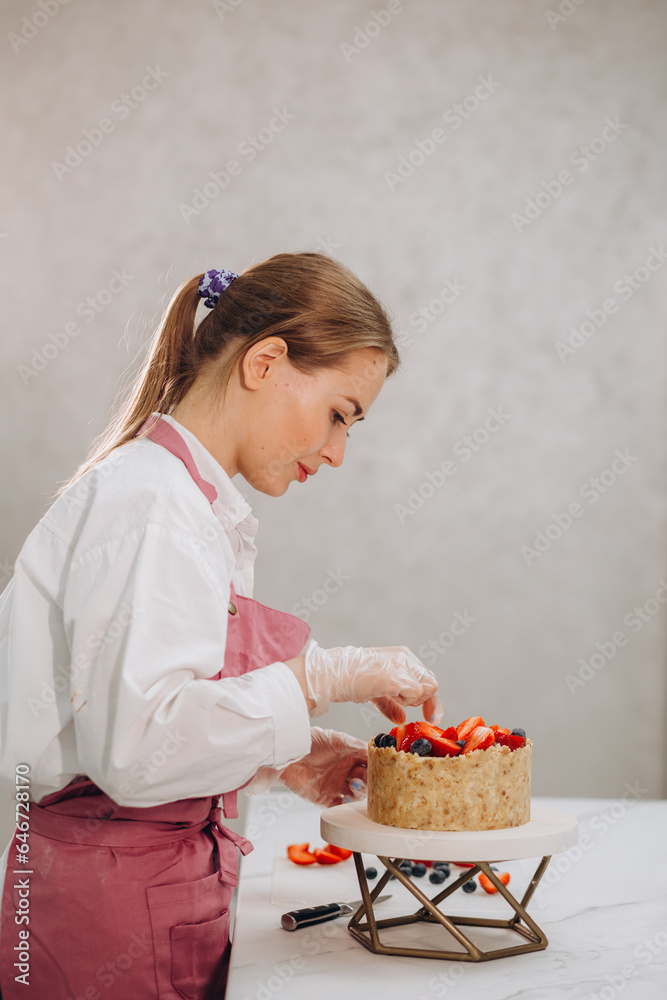 Woman decorating chocolate cake in the kitchen. Female chef making a cake at home. Woman decorating chocolate cake in the kitchen. Female chef making a cake at home.