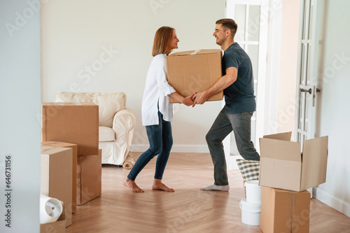 With one heavy box. Young couple moving to new home © standret