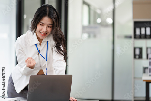 Asian business woman are excited business success with inspiration from their excellent financial results that are happy working in a modern office on a computer.