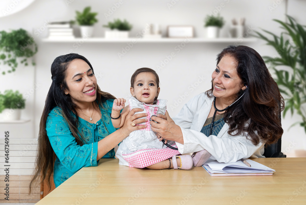 Young indian mother with her cute little baby visiting general pediatrician in modern clinic for routine check-up, Healthcare and medical concept. Young indian mother with her cute little baby visiting general pediatrician in modern clinic for routine check-up, Healthcare and medical concept.