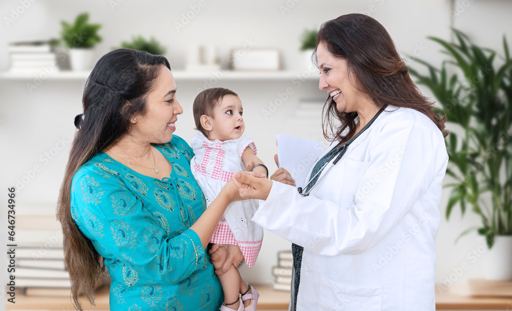 Fototapeta premium Young indian mother with baby visiting general pediatrician in clinic for routine check-up, Healthcare and medical concept.