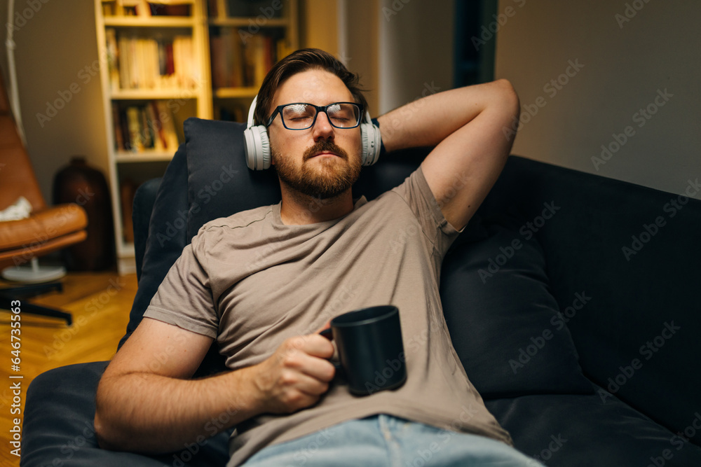 Obraz premium Adult man is resting with music at home.