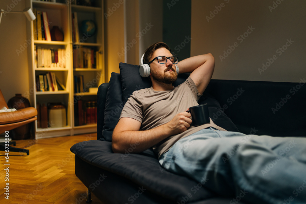 Caucasian man relaxing at home with enjoyable music. Caucasian man relaxing at home with enjoyable music.