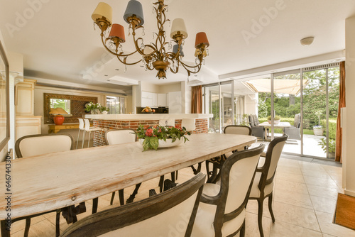 a dining room with a table, chairs and a chandel in the center of the room is an open patio