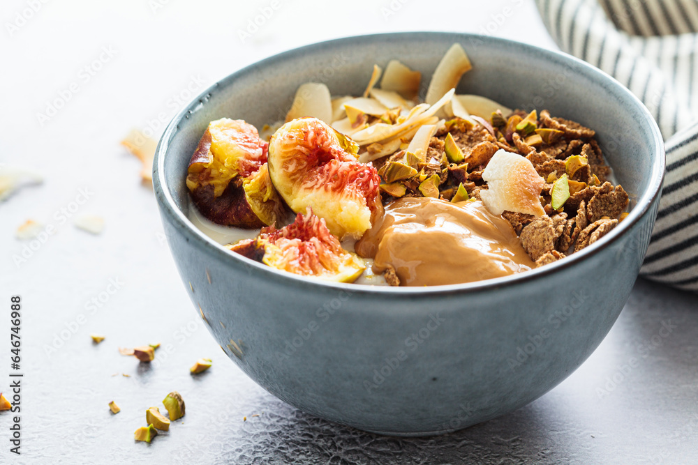 Multigrain breakfast cereals with fig, coconut chips, peanut butter and pistachio. Vegan breakfast concept. Multigrain breakfast cereals with fig, coconut chips, peanut butter and pistachio. Vegan breakfast concept.