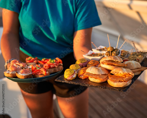 Waitresses serving a delicious meal at a beach bar in the mediterranean summer. Lifestyle concept