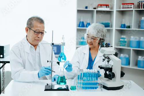 Asian senior Scientist team meeting and writing analysis results in the laboratory study and analyze scientific sample.