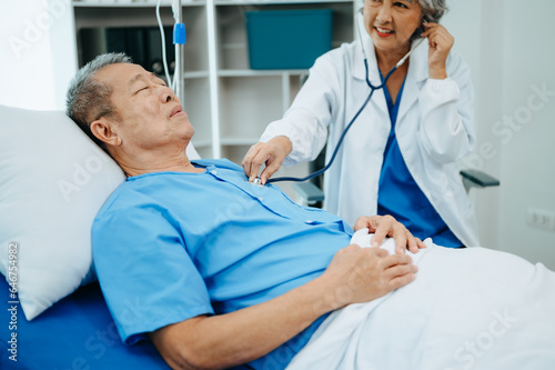 Female doctor holding male patient hand on the bed with receiving saline solution in hospital .