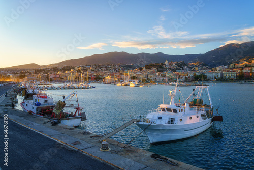 Panoramic view of Sanremo or San Remo from the sea  Italian Riviera  Liguria  Italy. Scenic sunset landscape with city architecture  seafront  mountains  blue water and sky  outdoor travel background