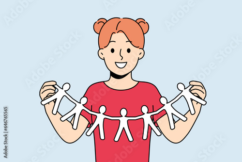 Little girl calls for solidarity and collaboration, showing paper people holding hands. Schoolgirl looks at screen with smile calling for solidarity and building alliances to fight discrimination
