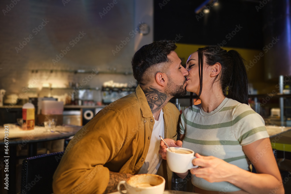 Couple kissing affectionately in a cafe