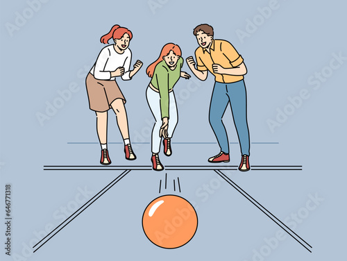 Cheerful friends play bowling together and support girlfriend thrower ball, wants to knock down pins. Young women and man visitors to bowling club experience excitement while playing