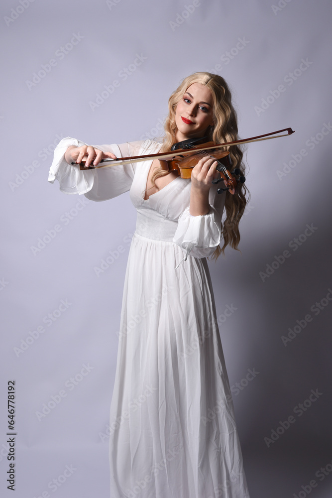 Close up portrait of beautiful blonde model wearing elegant white halloween gown, a historical fantasy character. Holding a violin musical instrument, isolated on studio background. Close up portrait of beautiful blonde model wearing elegant white halloween gown, a historical fantasy character. Holding a violin musical instrument, isolated on studio background.