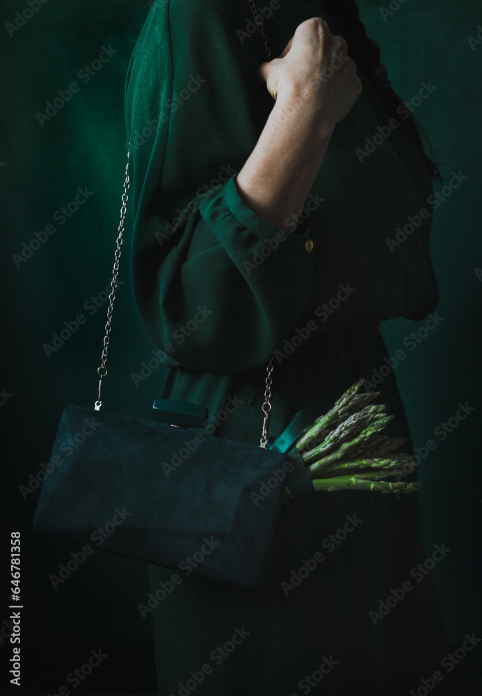 Woman in a green dress with a green handbag and green asparagus
