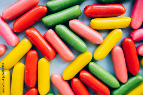 Mixed collection of colorful candy on blue background. Flat lay, top view