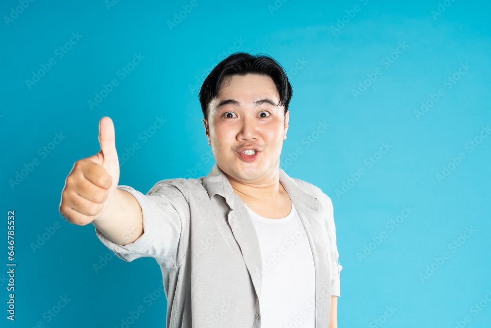 Portrait of an Asian guy posing on a blue background Portrait of an Asian guy posing on a blue background