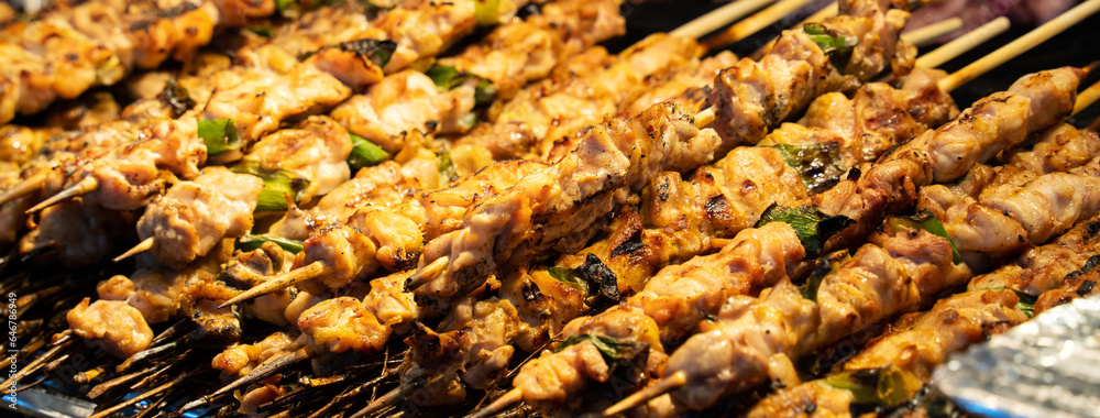 Grilling barbecue meat skewer kebab at traditional night market in South Korea.