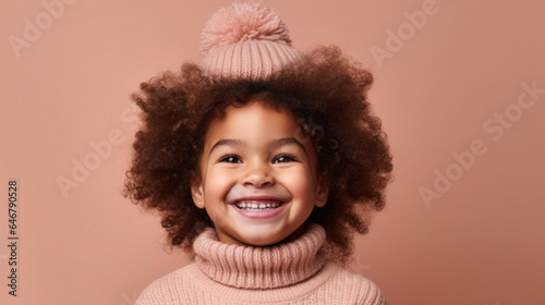 Adorable toddler girl in neutral clothing grinning against a studio light beige-pink backdrop. Generative AI