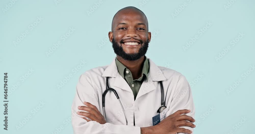 Face, happy black man and doctor with arms crossed in studio isolated on a blue background mockup space. Portrait, smile and confident medical professional, surgeon and healthcare worker in Nigeria. Face, happy black man and doctor with arms crossed in studio isolated on a blue background mockup space. Portrait, smile and confident medical professional, surgeon and healthcare worker in Nigeria.
