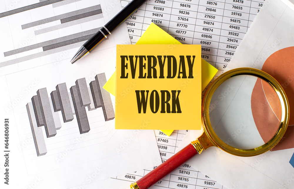 EVERYDAY WORK text on a sticky on the graph background with pen and magnifier EVERYDAY WORK text on a sticky on the graph background with pen and magnifier