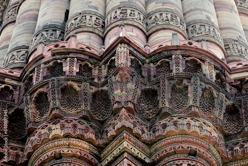 Decorative elements of Qutb Minar minaret tower part Qutb complex in South Delhi, India, ancient arabic inscriptions on big red sandstone minaret tower landmark popular touristic spot in New Delhi photo