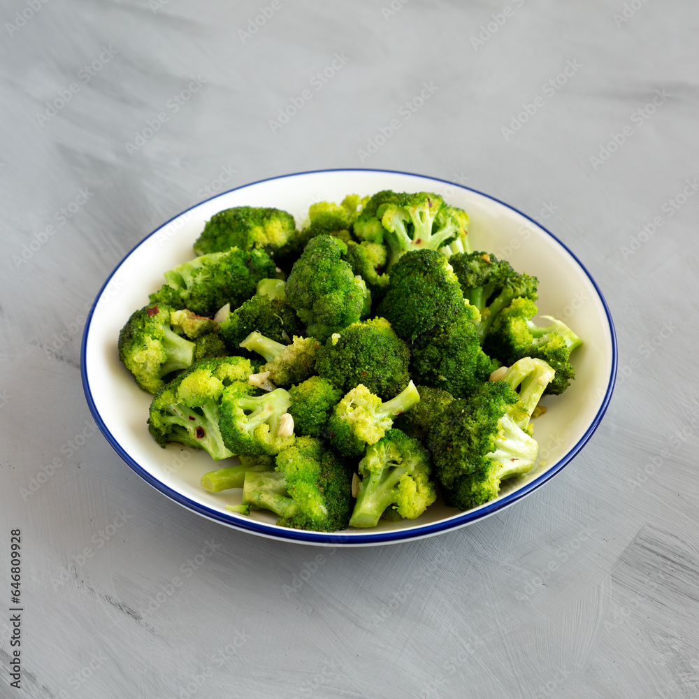 Homemade Pan-fried Broccoli on a Plate on a gray background, side view. Homemade Pan-fried Broccoli on a Plate on a gray background, side view.