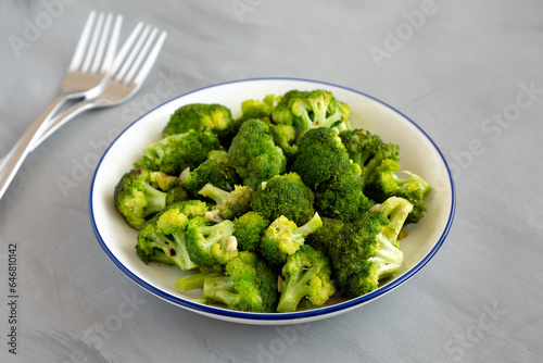 Homemade Pan-fried Broccoli on a Plate on a gray background, side view.