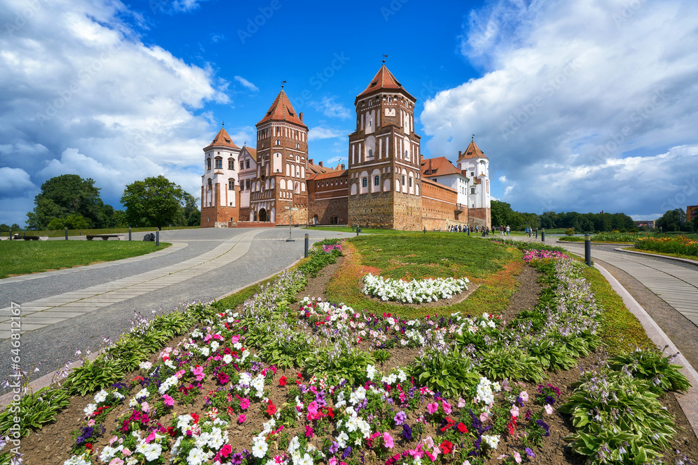 The Mir castle in Belarus with the flowers in front of it