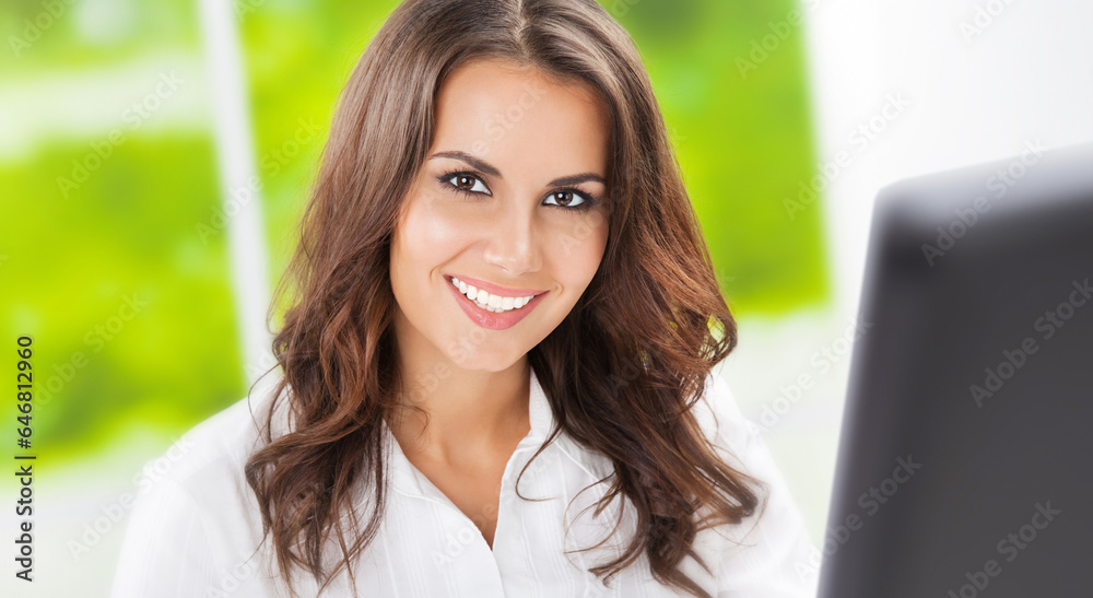 Happy smile businesswoman sitting at workplace with computer. Portrait of confident woman, executive employee, online consultant advisor in white blouse, on office window background. Business concept. Happy smile businesswoman sitting at workplace with computer. Portrait of confident woman, executive employee, online consultant advisor in white blouse, on office window background. Business concept.