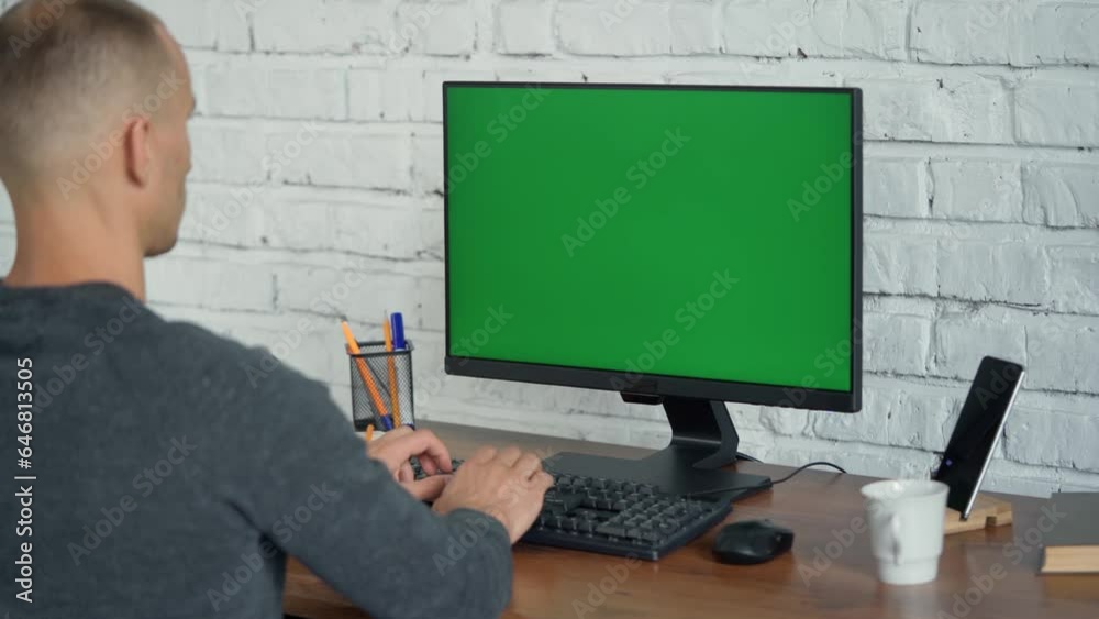 Man Typing on Keyboard and Looking at Green Screen Computer.Chrome key On Display Man Typing on Keyboard and Looking at Green Screen Computer.Chrome key On Display