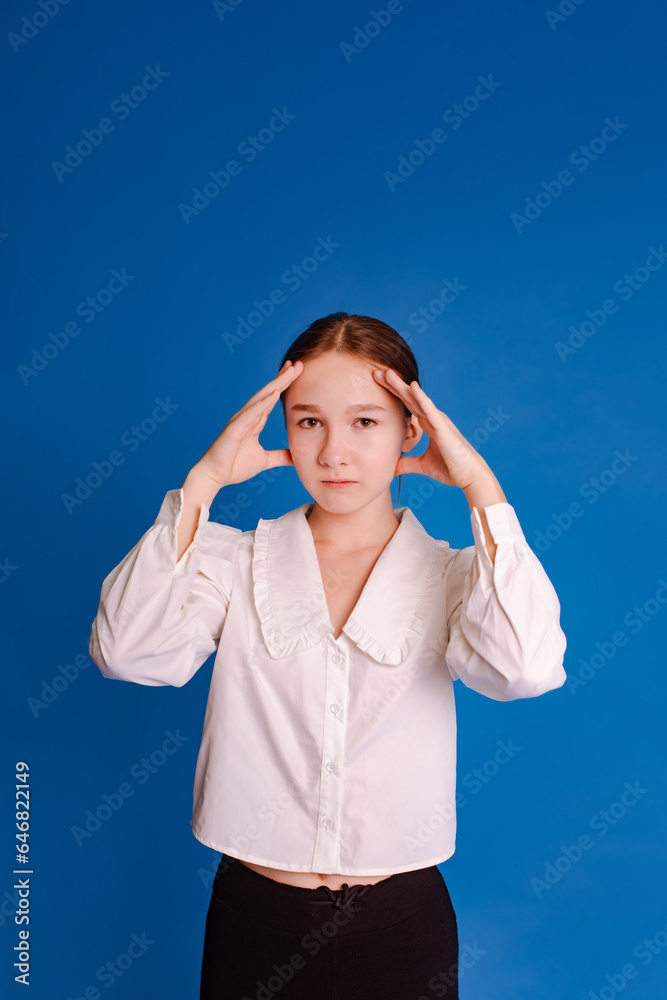 student teen girl holding head in hands over blue background. problem of choice and decision-making concept student teen girl holding head in hands over blue background. problem of choice and decision-making concept
