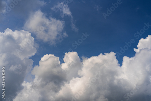 Blue sky with dramatic cumulus clouds creating contrast. A stunning weather phenomenon showcasing the beauty of nature. Cloudy sky with a mixture of light and shadows. Atmospheric scene