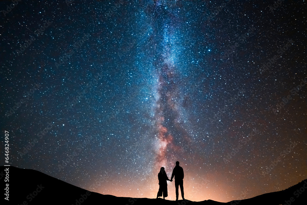Fantasy landscape, couple in love standing on the hill, and looking at the Milky Way galaxy . - obrazy, fototapety, plakaty 