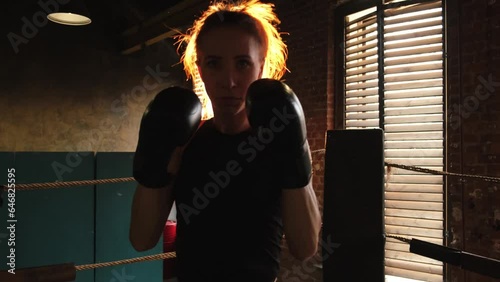 Women self defense girl power. Strong woman fighter punching with boxing gloves to camera. Healthy strong girl punching training punches looking concentrated straight. Fit body workout