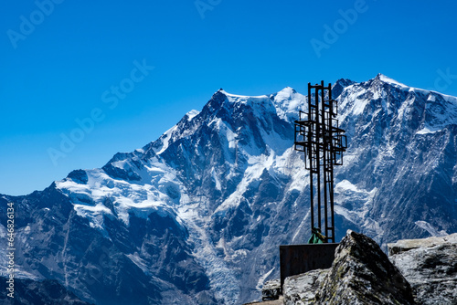 Croce di vetta sullo Joderhorn. Sullo sfondo la parete Est del Monte Rosa photo