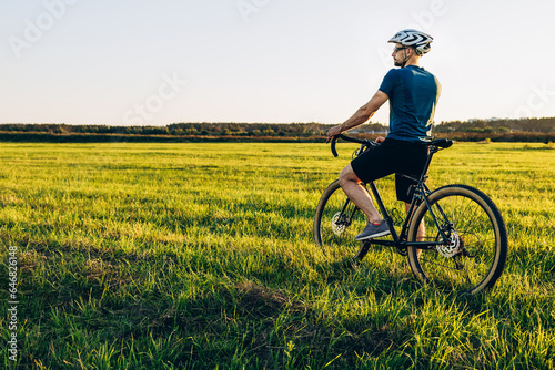Male caucasian cyclist standing with his bike. Young pretty athletic man with bicycle outdoor. Active sporty people concept image
