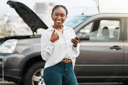 Car insurance, mobile or portrait of happy woman with thumbs up on road typing message for help. Smile, phone service or African driver by a stuck motor vehicle texting on social media or online photo