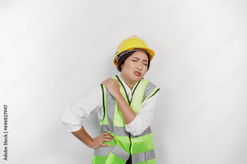 Tired Asian woman labor worker wearing a safety helmet and vest suffering from pain, muscle spasm isolated white background. Labor's day concept.