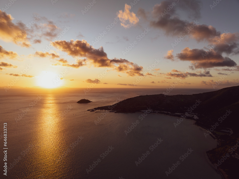 Aerial sunset view of Hayman Island, Whitsunday Islands, Queensland, Australia, near Great Barrier Reef. Popular tourist destination with a resort hotel. Queensland mainland coast in the background.