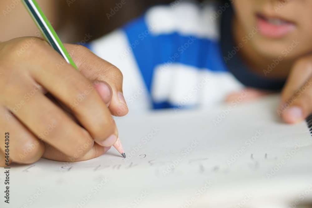 Mother holds hands with son to practice writing letters Mother holds hands with son to practice writing letters