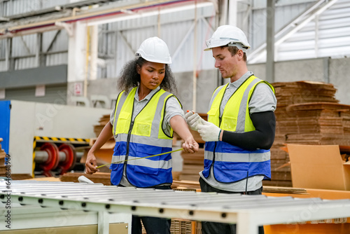 Industrial worker indoors in factory. Young technician with orange hard hat. Smart Caucasian factory worker wearing hardhat and working in power plant.