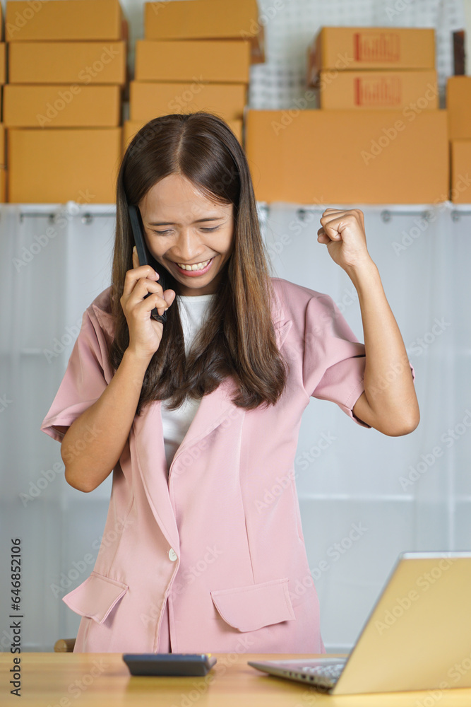 Online seller talking on the phone with customers happily from closing product deals Online seller talking on the phone with customers happily from closing product deals