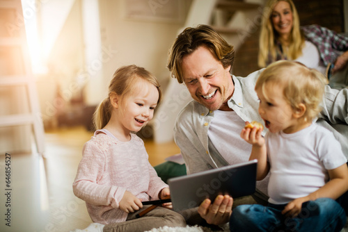 Young family using a tablet and playing at home