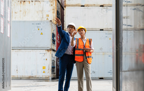 Workers having discussion against cargo containers