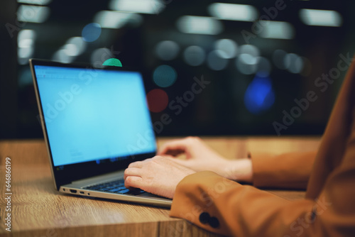 Businesswoman in a suit works on a laptop.